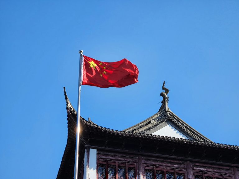 A Chinese flag flying on a building.