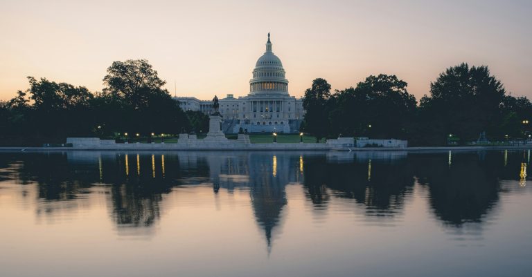 The U.S. Capitol is reflected in the water.