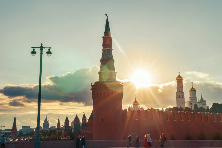 Panoramic view of central Moscow at sunset, featuring the Kremlin bathed in golden light.
