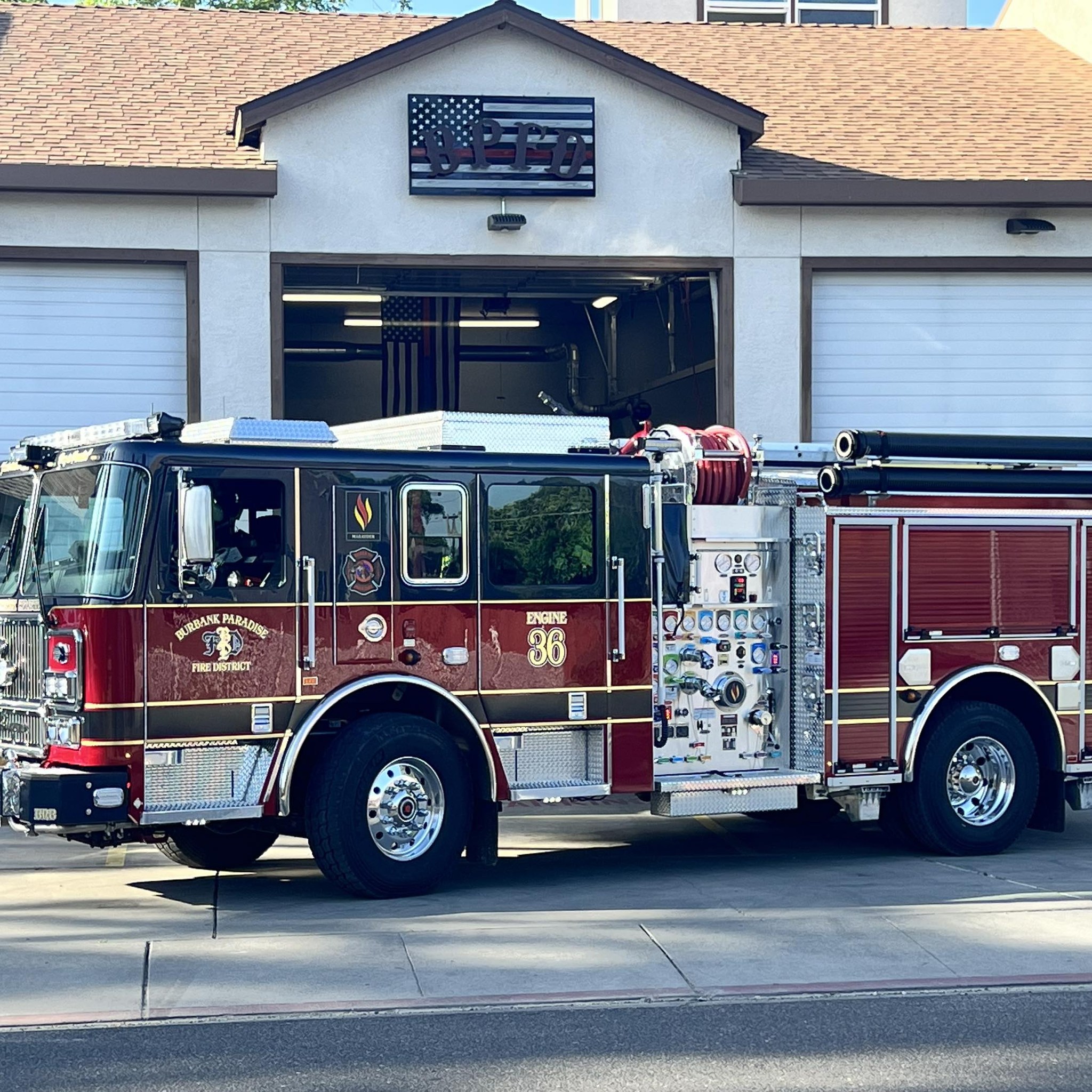 A red and black Burbank Paradise Fire District fire engine, marked as Engine 36, parked in front of the BPFD fire station.