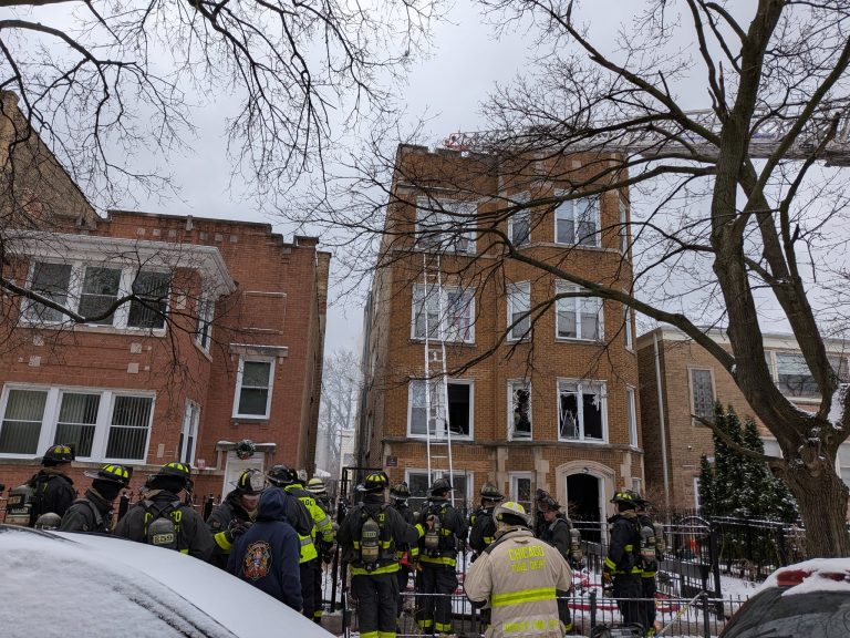 Exterior view of a four-story residential building in Rogers Park, Chicago, the site of a fatal fire involving a Chicago Fire Department member.