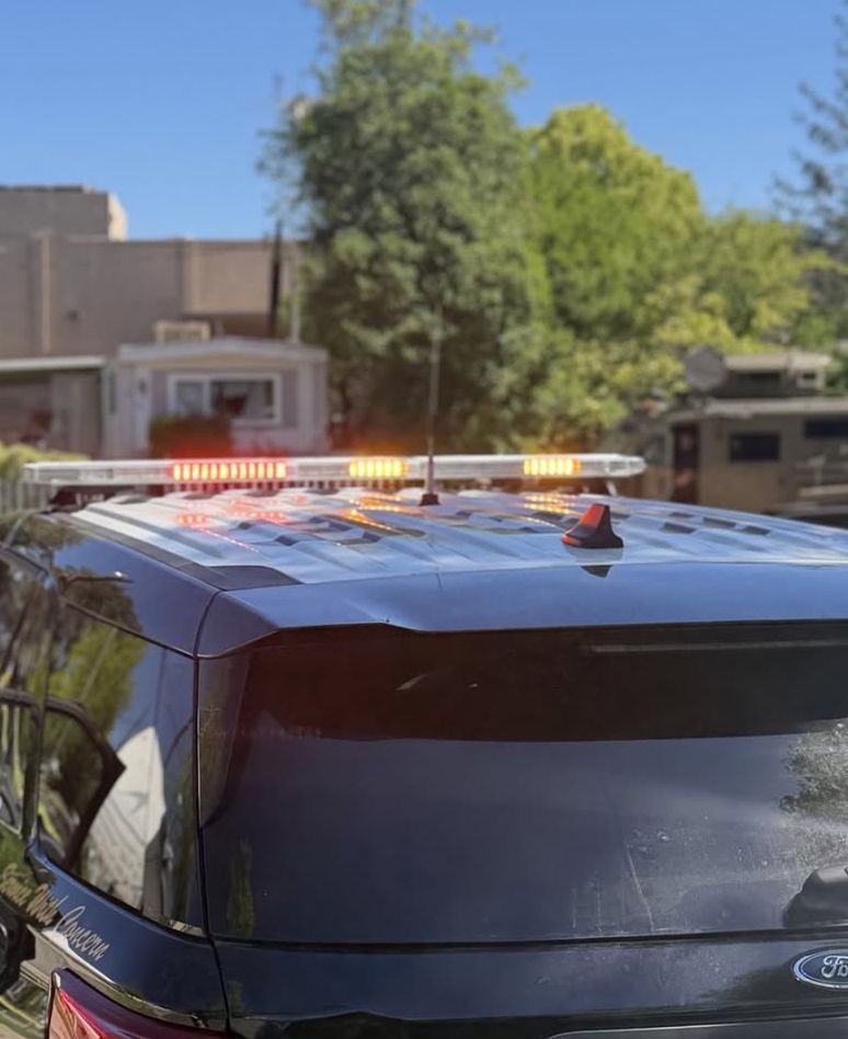 A close-up of a Sacramento County Sheriff’s patrol vehicle, lights flashing, at the scene of the Orangevale mobile home park shooting.