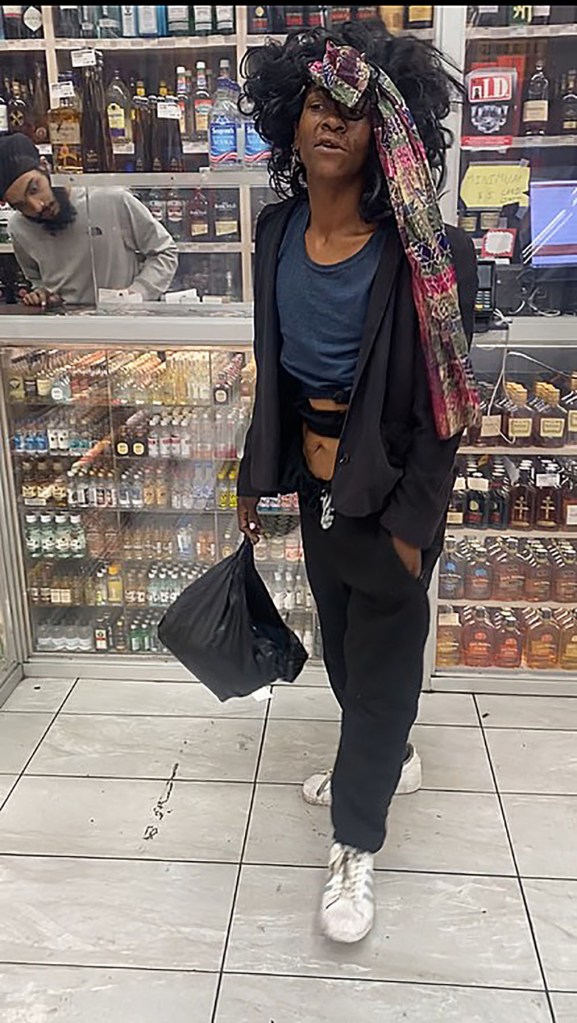Kianna Underwood standing inside a liquor store, holding a black plastic bag.