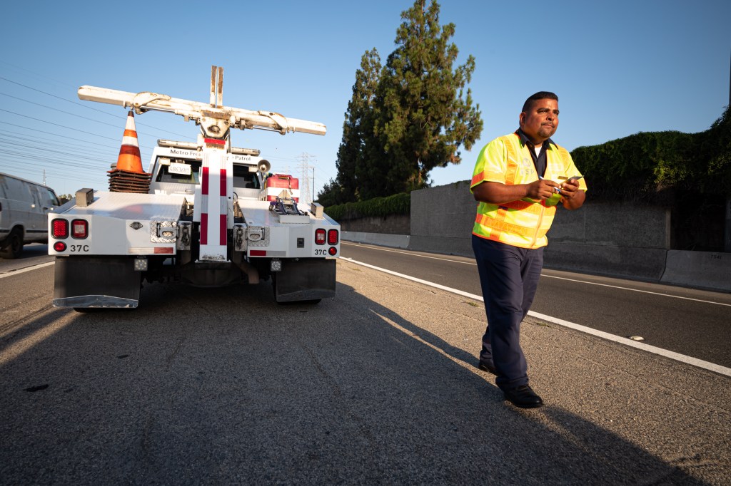 A vehicle in road with a worker.