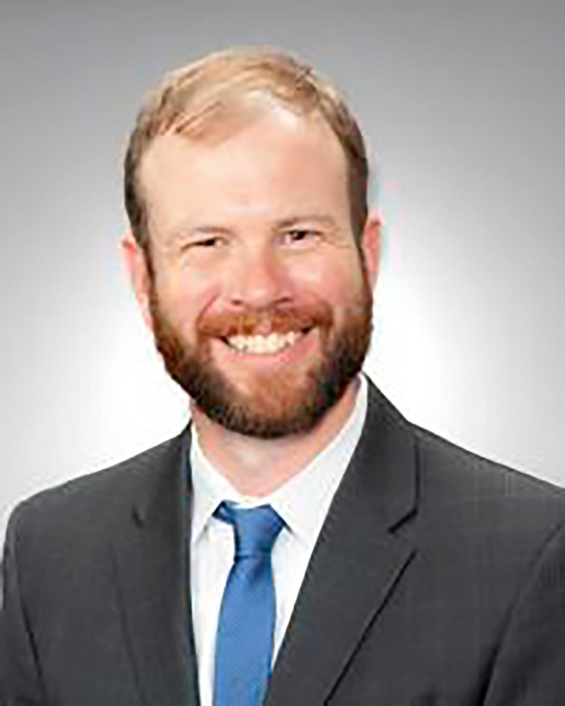Portrait of Elijah Hemingway in a suit and tie.